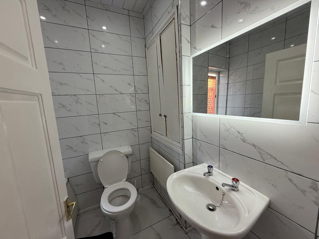 Bright, modern bathroom with marble-effect tile...