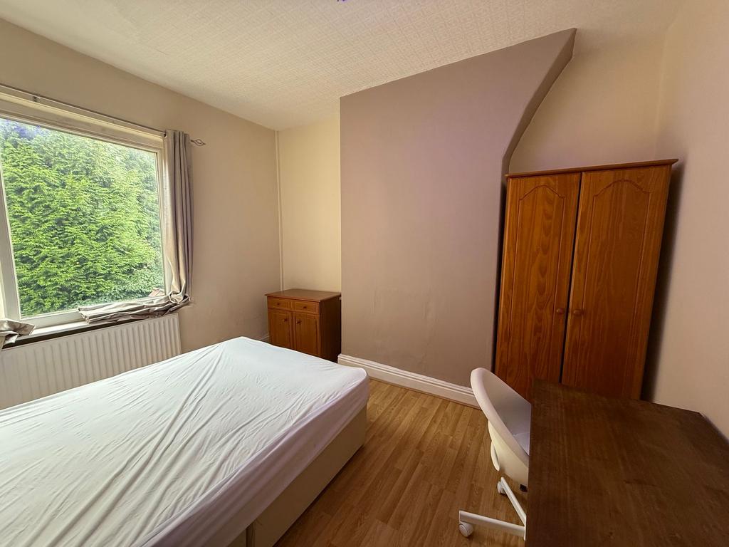 Bright, simply furnished bedroom with a large w...