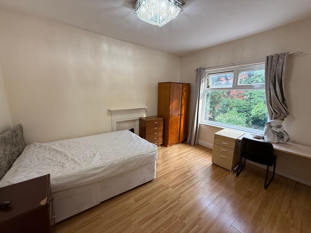 Bright, neutrally decorated bedroom with large ...