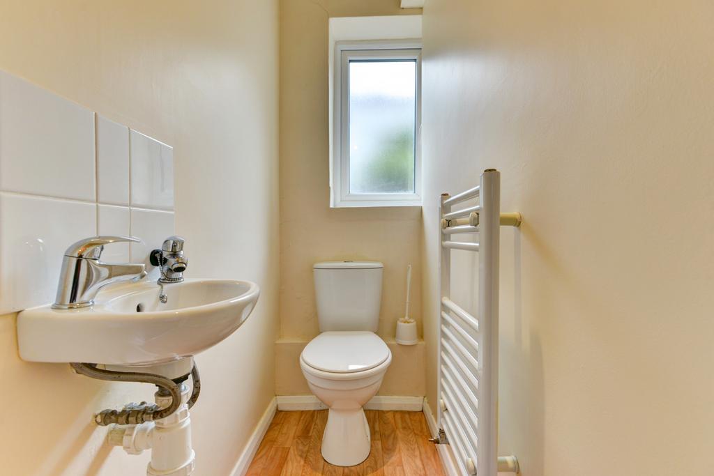A clean and bright bathroom with a toilet, a sm...