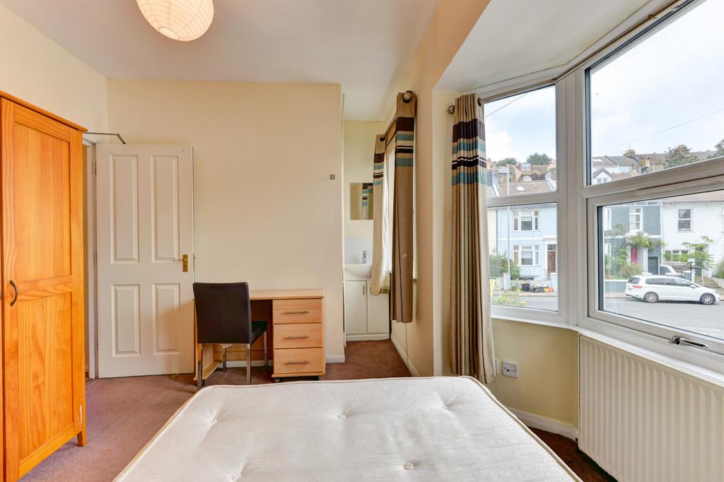 Bright double bedroom with a large bay window a...