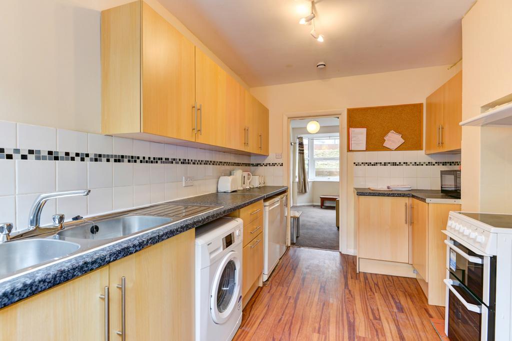 Bright galley-style kitchen with wood-effect fl...