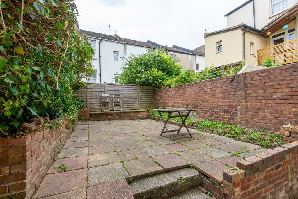 Low-maintenance paved rear garden with raised b...