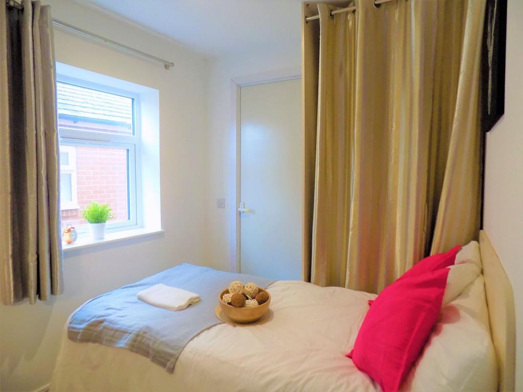 Cozy single bedroom featuring a bright window w...