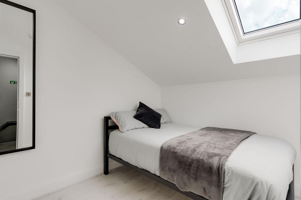 A cozy, bright bedroom with a comfortable bed, ...