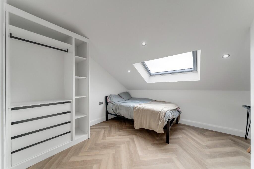 Bright and modern bedroom with a skylight windo...