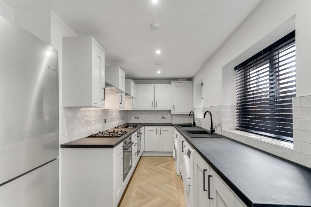 A modern, well-maintained kitchen with ample wo...