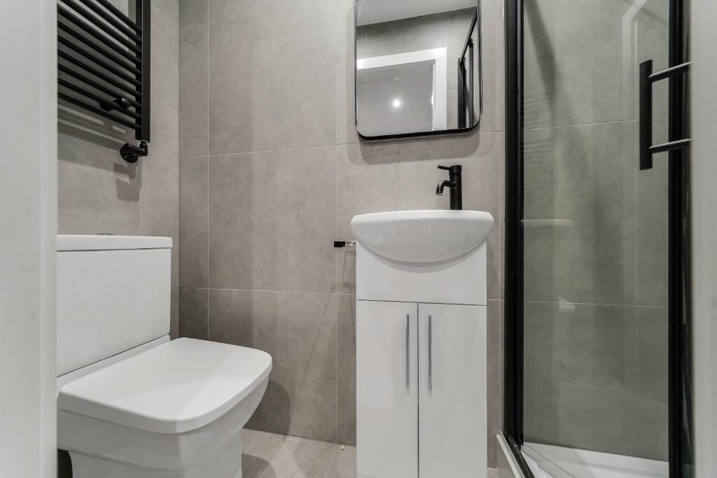 Modern and clean bathroom featuring a toilet, a...
