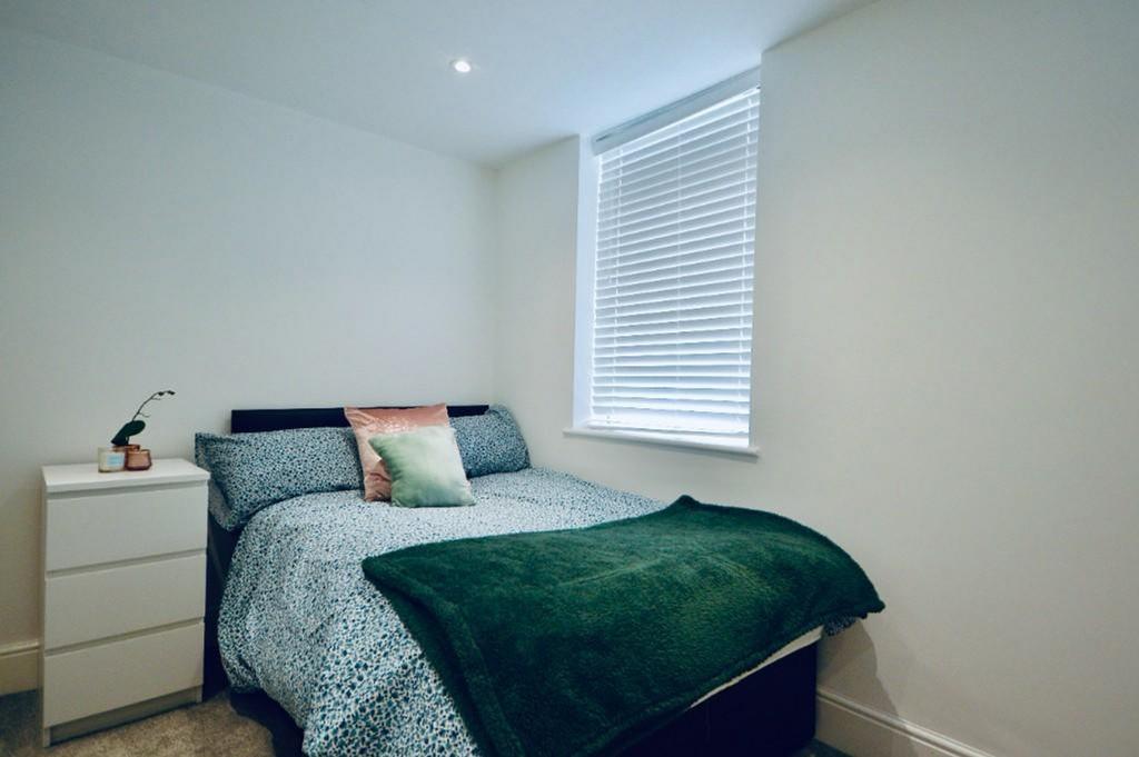 This cozy double bedroom features a comfortable...