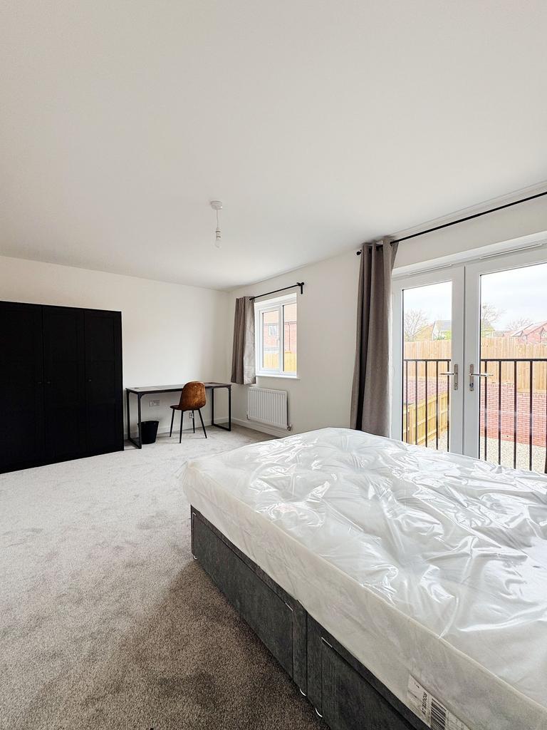 Bright, modern bedroom with large floor-to-ceil...