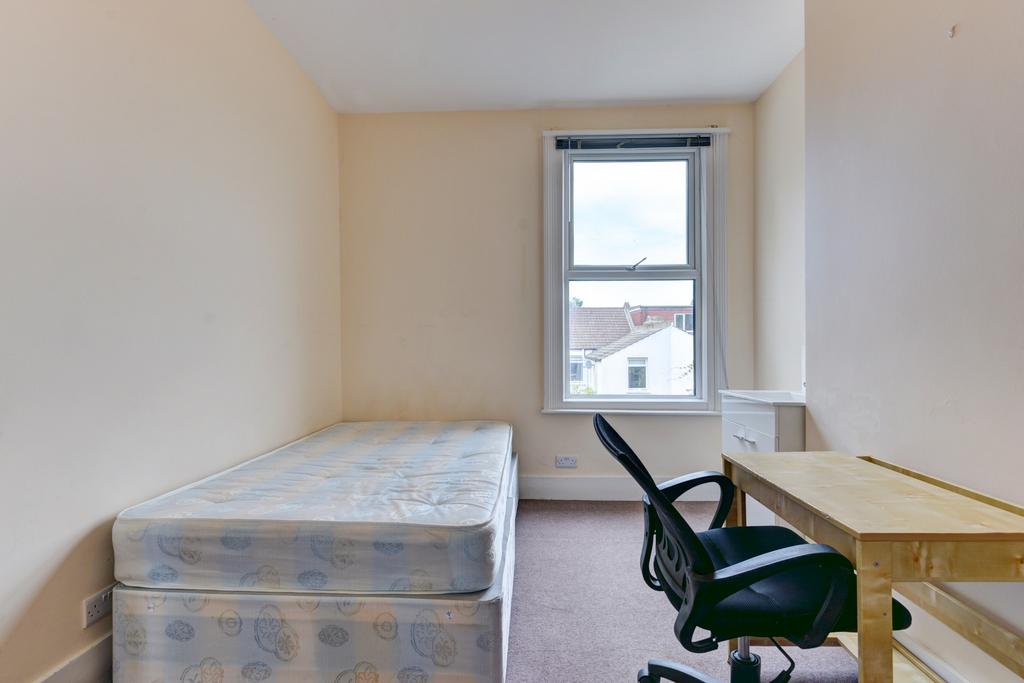 Bright, simply furnished bedroom with a single ...