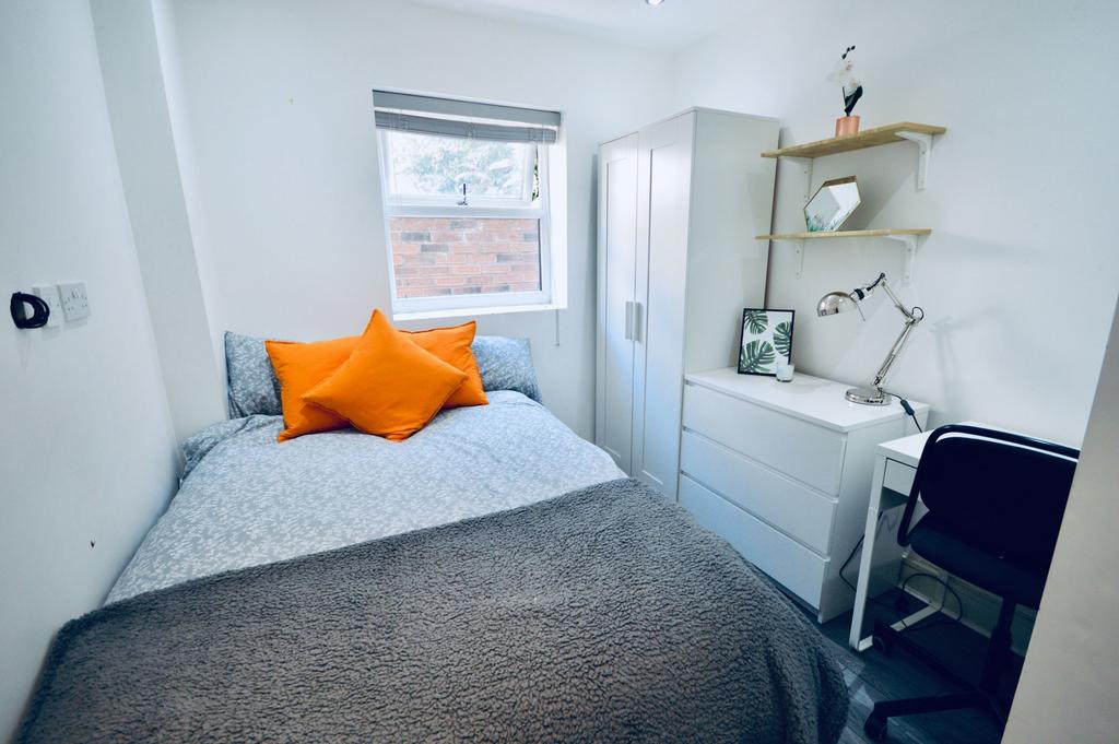 A cozy bedroom featuring a double bed with vibr...