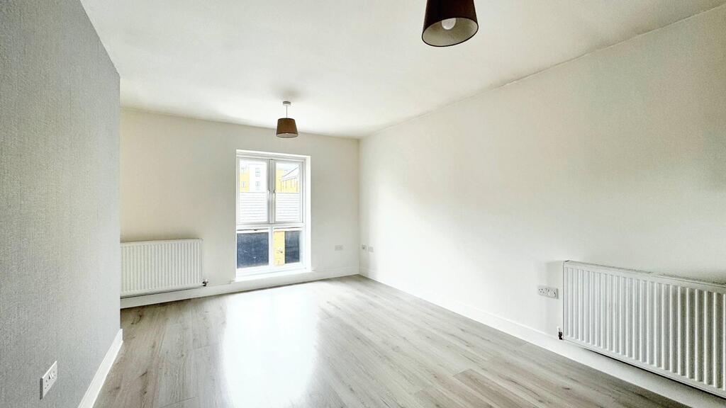 Bright, neutral living room with light wood flo...