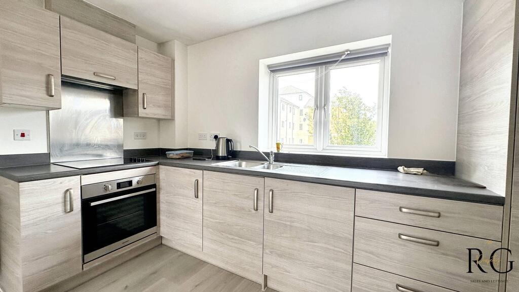 Modern fitted kitchen with light wood-effect ca...