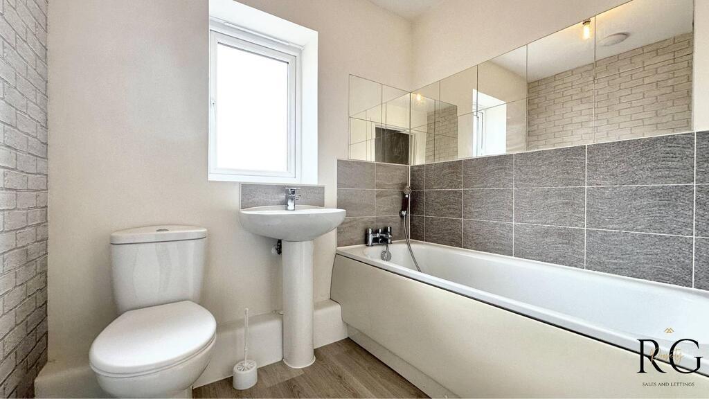 Bright modern bathroom with a white bathtub, pe...