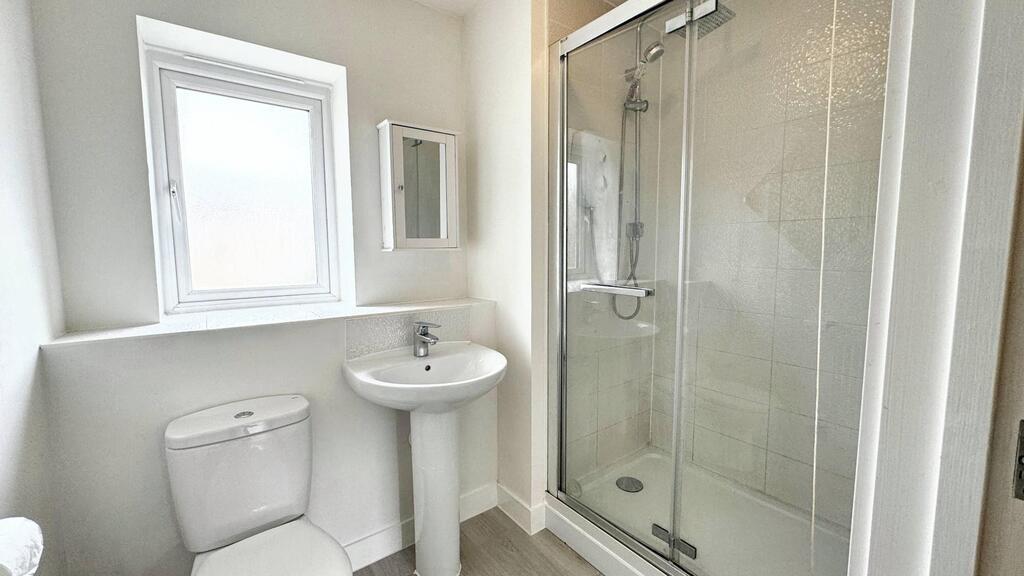 Bright, modern bathroom with a walk-in shower c...