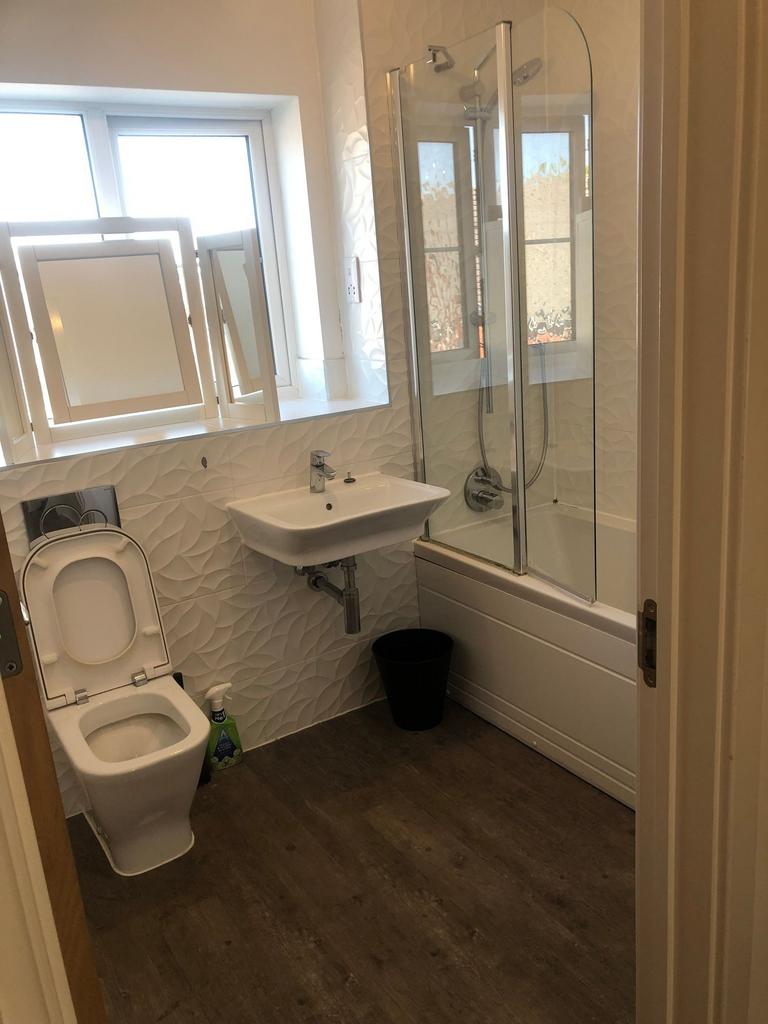 Bright, modern bathroom with textured white wal...