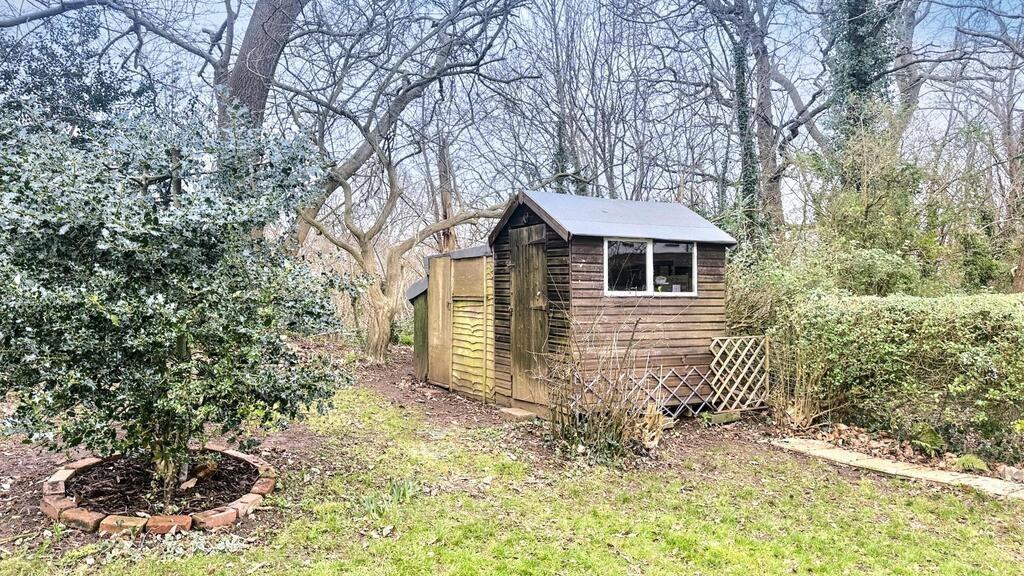 Private garden area with mature trees and a woo...