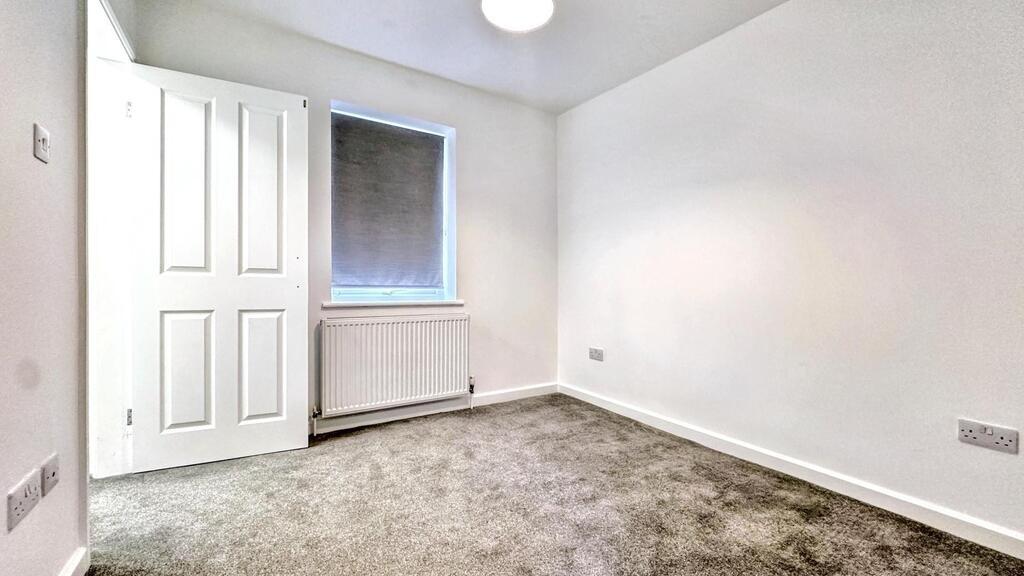 Bright, freshly painted small bedroom with neut...