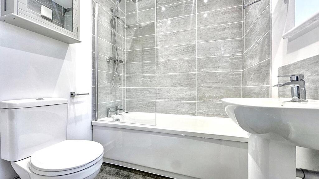 Bright, modern bathroom featuring a full-size b...