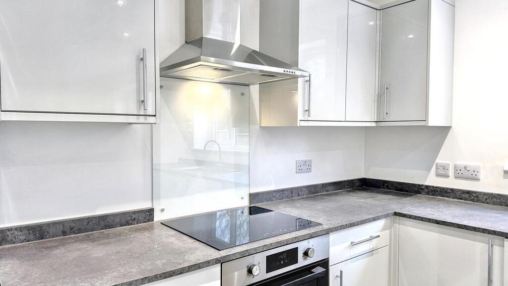 Bright modern kitchen with white gloss cabinets...