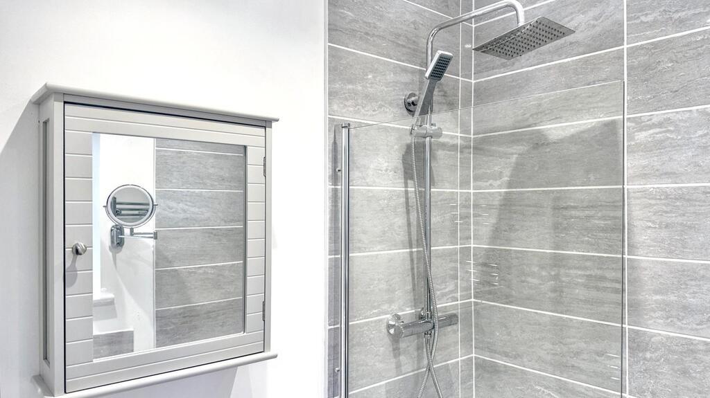 Bright modern bathroom with a walk-in shower fe...
