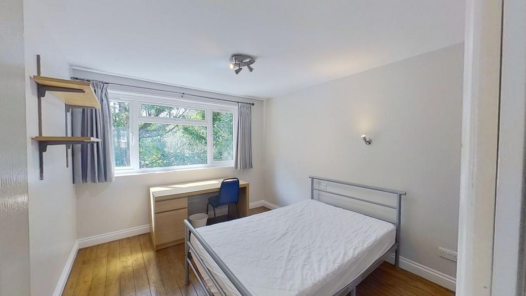 Bright, simply furnished bedroom with a double ...