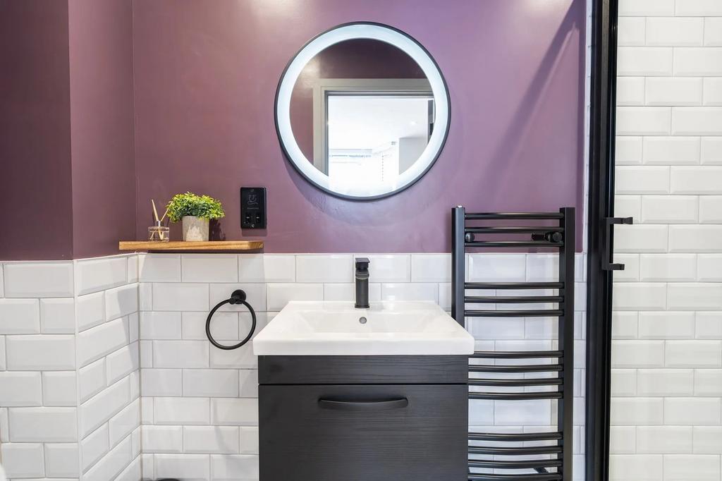 A modern bathroom featuring a stylish round mir...