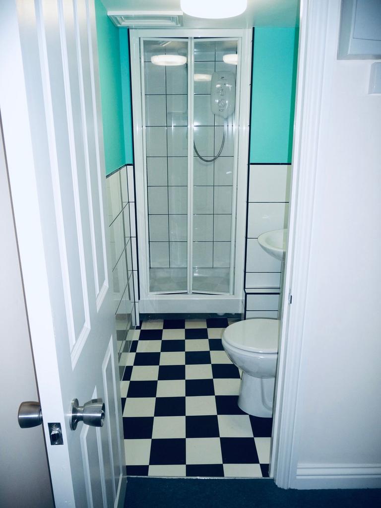 Bright, tidy bathroom with a corner shower cubi...
