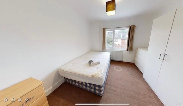 Neat, simply furnished bedroom with a comfortab...