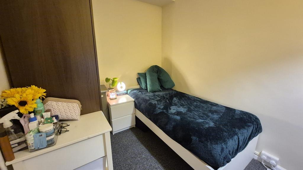 Cozy single bedroom with a neatly made bed, bed...