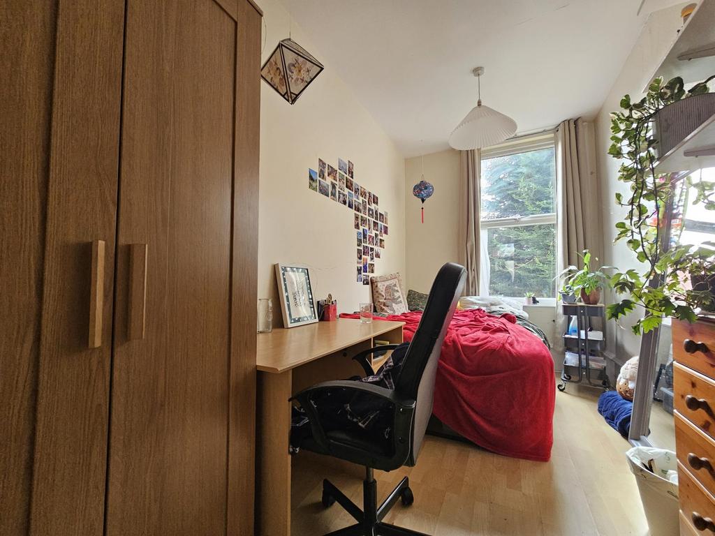 Bright, neatly arranged bedroom with a large wi...