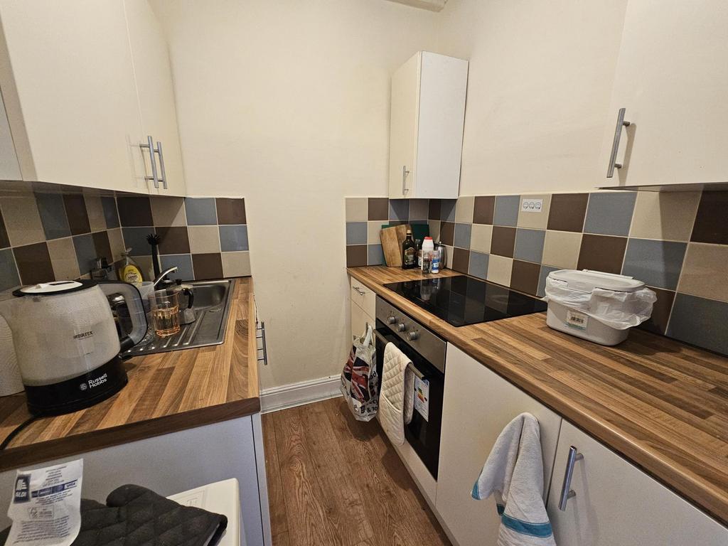 Neat, modern kitchen with wood-effect worktops,...