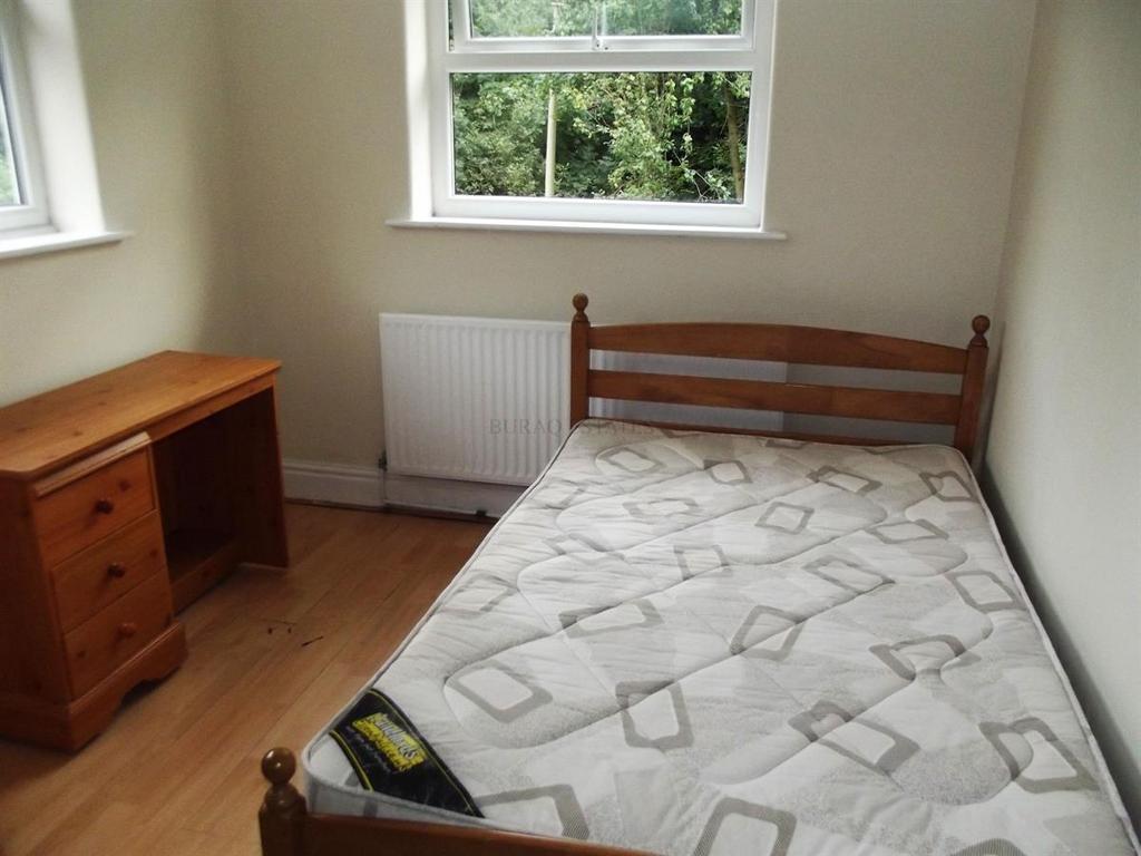 Bright, simply furnished bedroom with a single ...