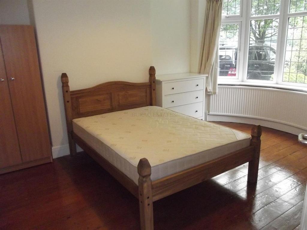 Bright double bedroom with a wooden bed frame, ...