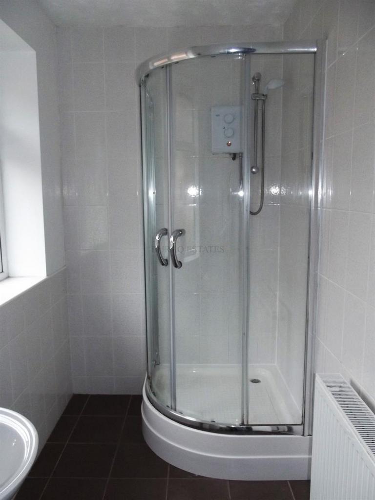 Bright, modern bathroom with a curved glass sho...