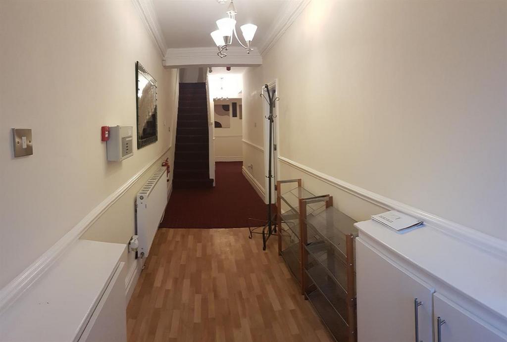 Well-maintained entrance hallway with wall pane...