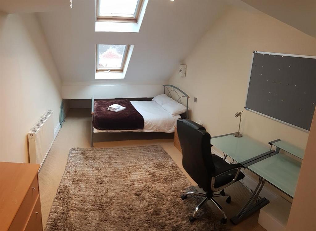 Bright attic bedroom with skylight windows, a n...