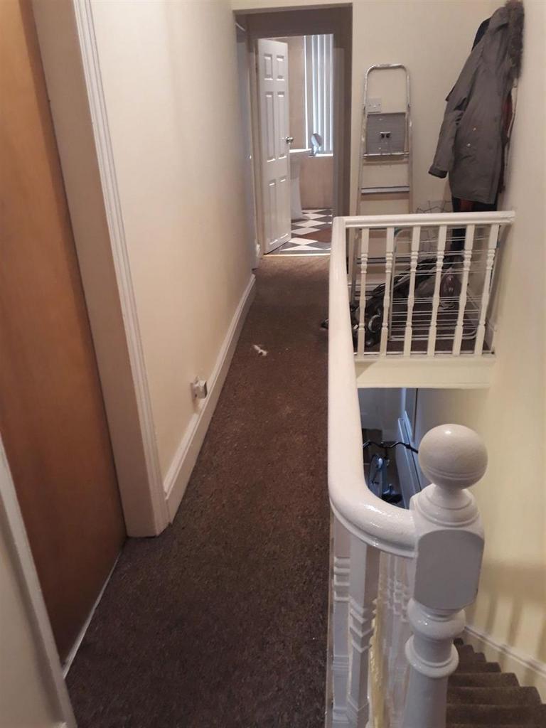 Bright upstairs hallway with neutral walls, car...