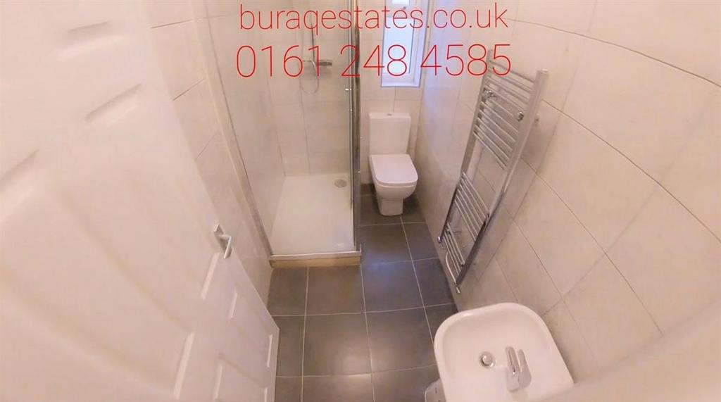 Compact, modern bathroom with tiled walls and f...