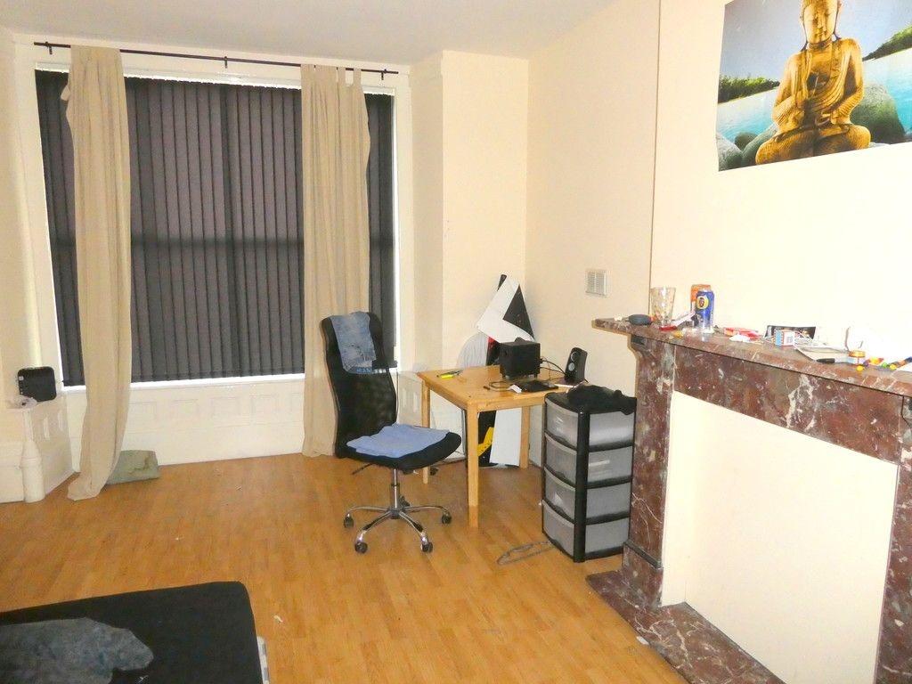 Bright, neatly presented bedroom featuring wood...