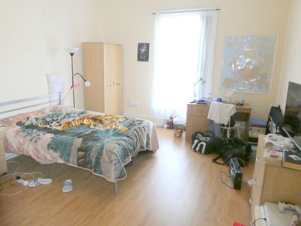Bright double bedroom with large window, wooden...