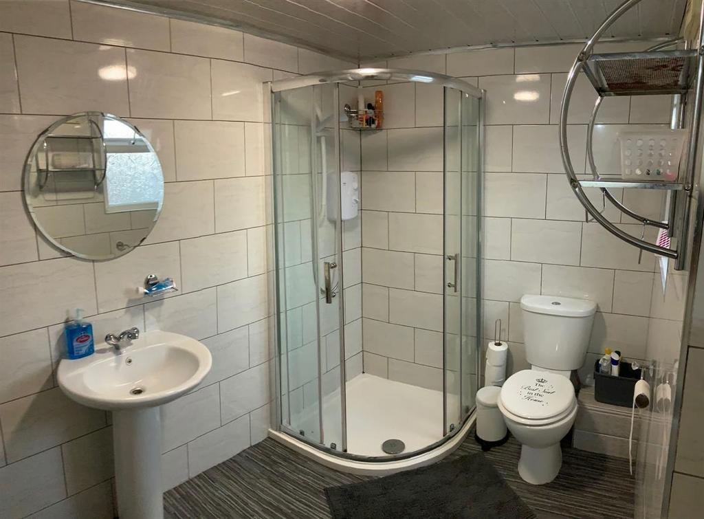 Bright, modern bathroom with a curved glass sho...