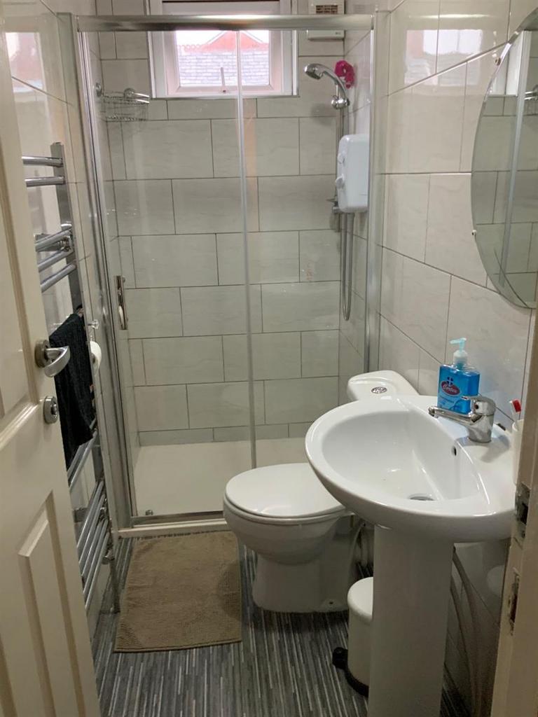 Bright, modern tiled bathroom with a walk-in gl...