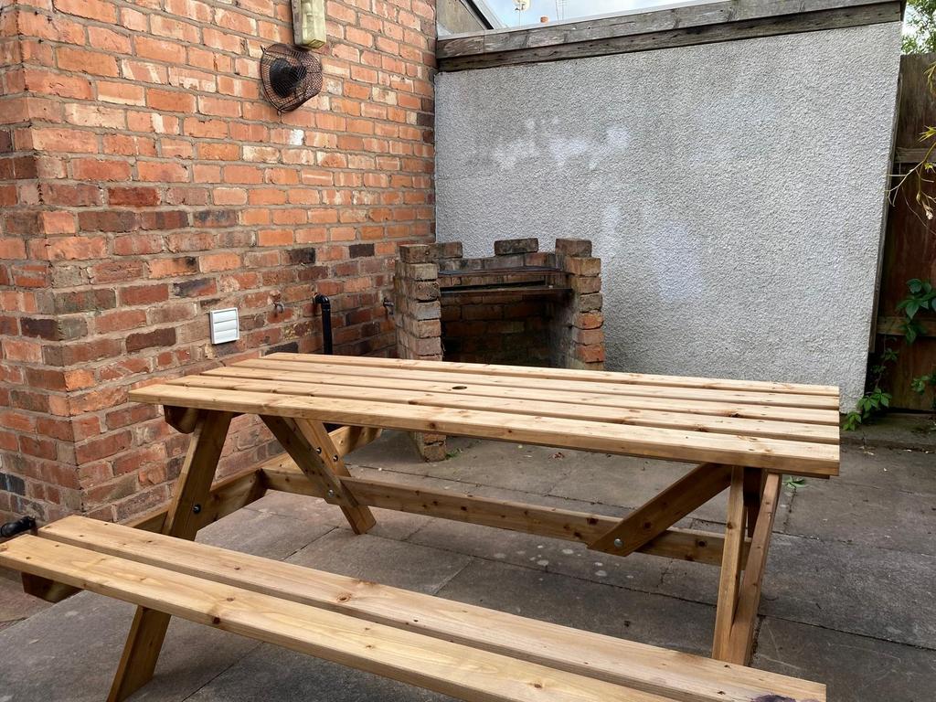 Private paved garden corner with a sturdy woode...