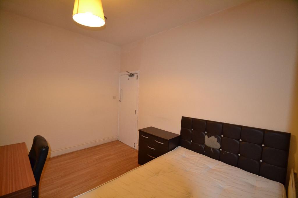 A bedroom featuring a black upholstered headboa...