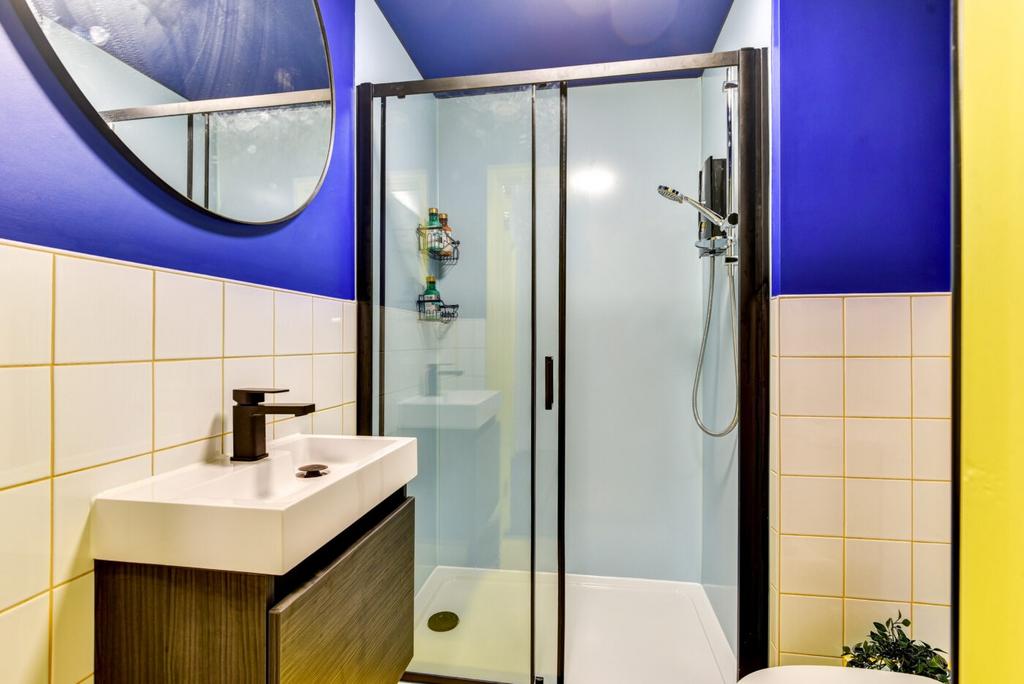 Bright contemporary bathroom with bold blue wal...