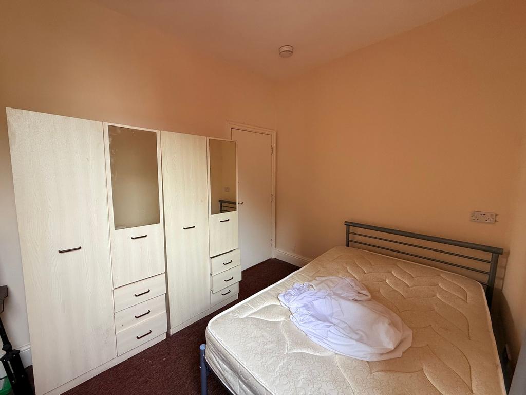 Bright, simply furnished bedroom with a metal d...