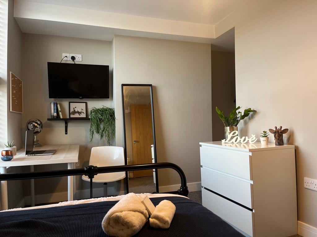 Bright, neatly styled bedroom with a desk works...