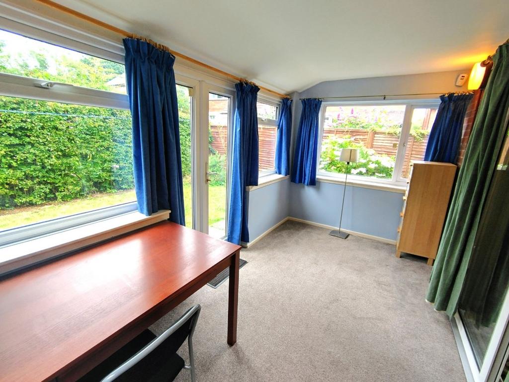 Bright, carpeted workspace with large windows a...